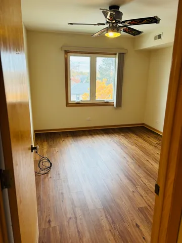 a view of empty room with wooden floor