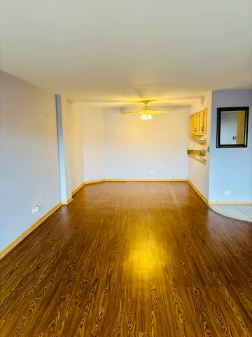 a view of a big room with wooden floor and windows