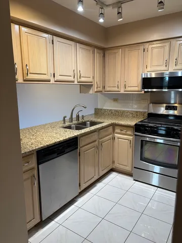 a kitchen with granite countertop a sink dishwasher stove and cabinets