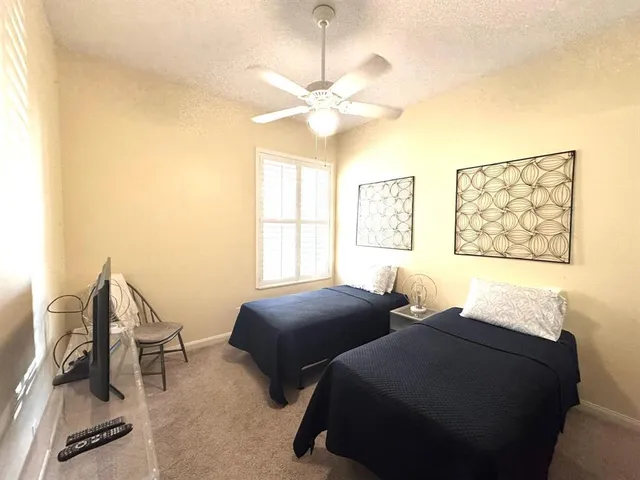 a bedroom with two beds and a large window