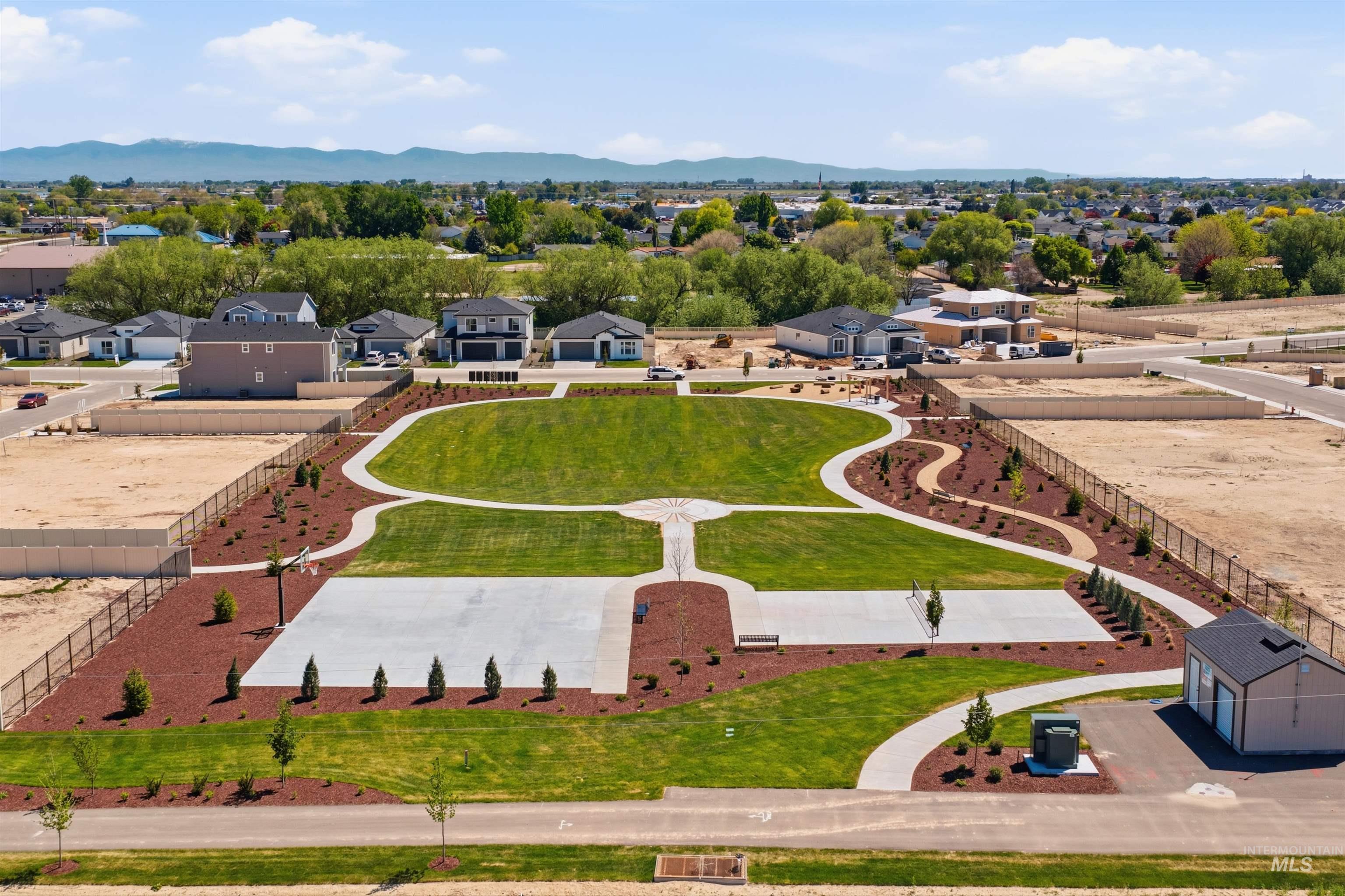 3405 Elliptical Lane Caldwell, ID 83607 - Photo 15 of 17 Community green space featuring expansive lawns, concrete pathways, mature trees, and a dedicated concrete court