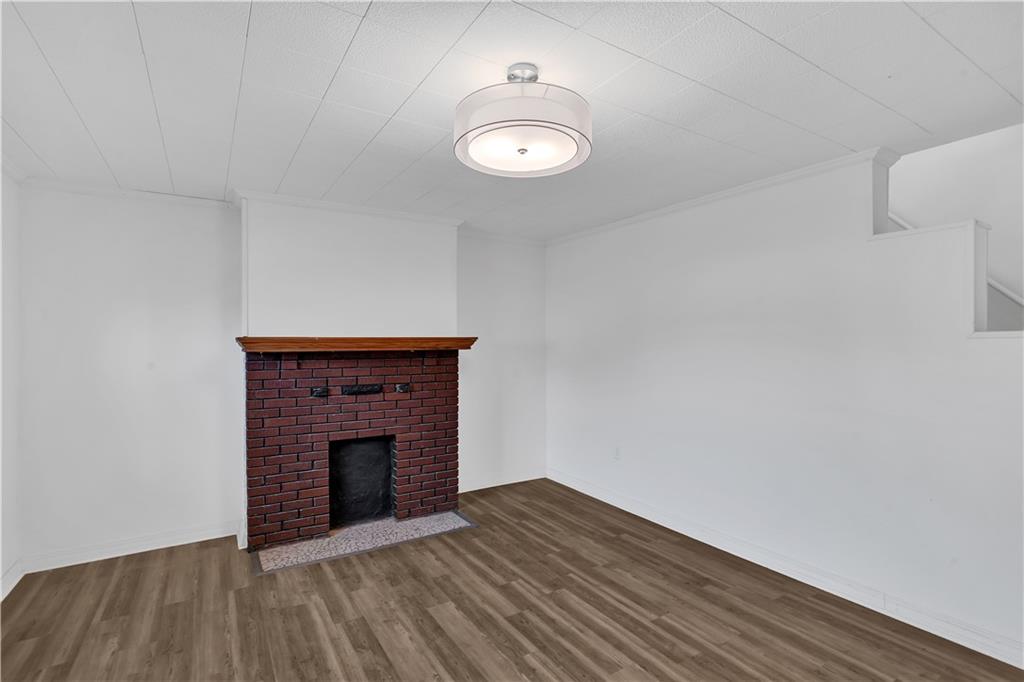 1841 Chislett Street Pittsburgh, PA 15206 - Photo 7 of 28 a view of empty room with wooden floor and fireplace