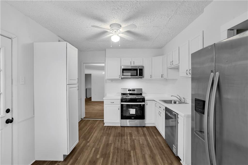1841 Chislett Street Pittsburgh, PA 15206 - Photo 10 of 28 a kitchen with a refrigerator a stove top oven and wooden floor