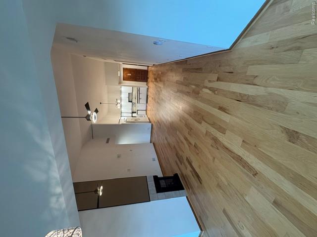 875 GreenView Court, Unit 62 Rochester, MI 48307 - Photo 5 of 19 Expansive open-concept living area with wood-finish flooring, a fireplace featuring a stone surround, and vaulted ceilings