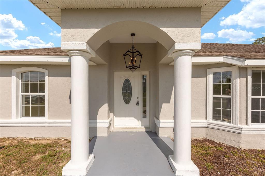 15434 Southwest 23rd Court Road Ocala, FL 34473 - Photo 4 of 41 a front view of a house with a porch