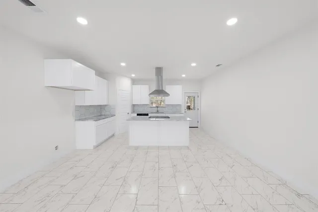 a large kitchen with kitchen island a stove a sink dishwasher and a refrigerator