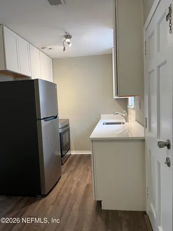 a utility room with wooden floor washer and dryer