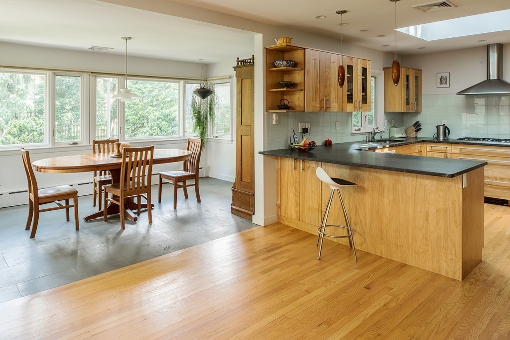 39 Clements Road Newton, MA 02458 - Photo 2 of 11 a dining hall with stainless steel appliances granite countertop a stove a sink a dining table and chairs with wooden floor