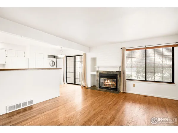 a view of empty room with a fireplace and wooden floor