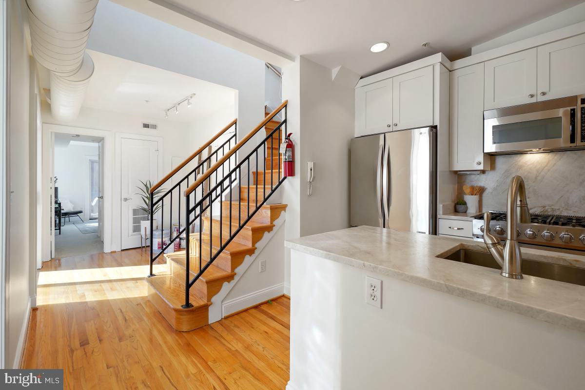 1832 Swann Street Northwest, Unit D Washington, DC 20009 - Photo 11 of 29 a kitchen with stainless steel appliances granite countertop a refrigerator a stove and a sink