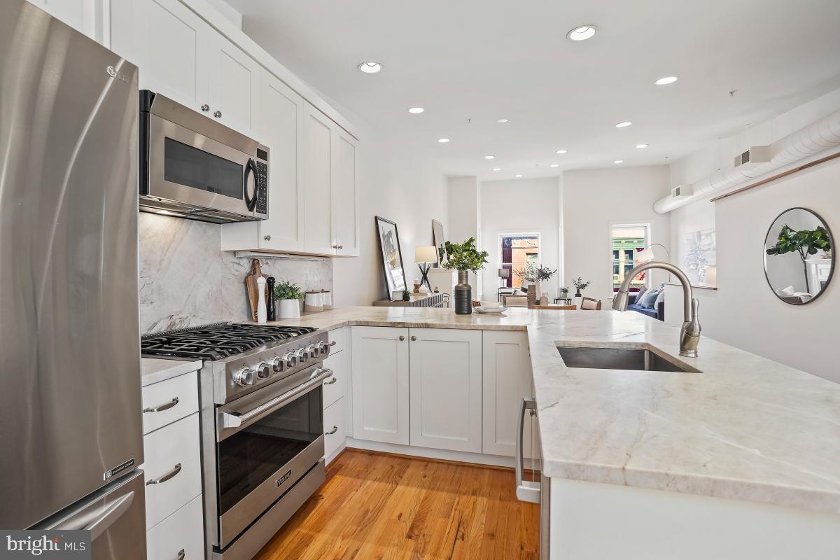 1832 Swann Street Northwest, Unit D Washington, DC 20009 - Photo 2 of 29 a kitchen with stainless steel appliances granite countertop a stove a sink and a microwave