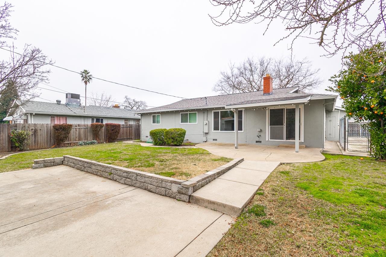 2855 La Colina Way Carmichael, CA 95608 - Photo 17 of 25 a view of a white house with a large tree next to a yard
