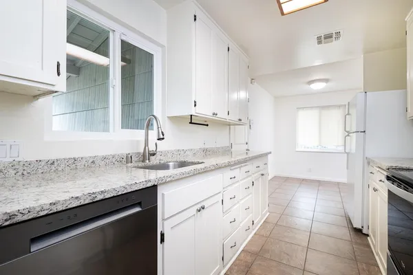 a kitchen with granite countertop a sink and cabinets