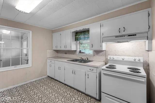 a kitchen with granite countertop white cabinets and white appliances