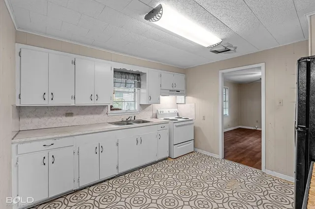 a kitchen with granite countertop white cabinets and sink