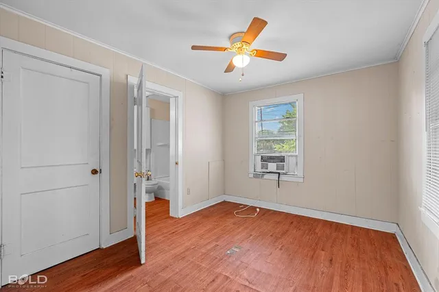 an empty room with wooden floor and window