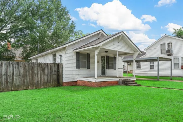 a front view of house with backyard and green space