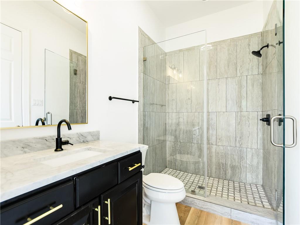 13301 Lone Rider Trail Bee Cave, TX 78738 - Photo 15 of 21 This bathroom features a contemporary vanity with a marble countertop, a sleek black faucet, and a large mirror with a gold frame
