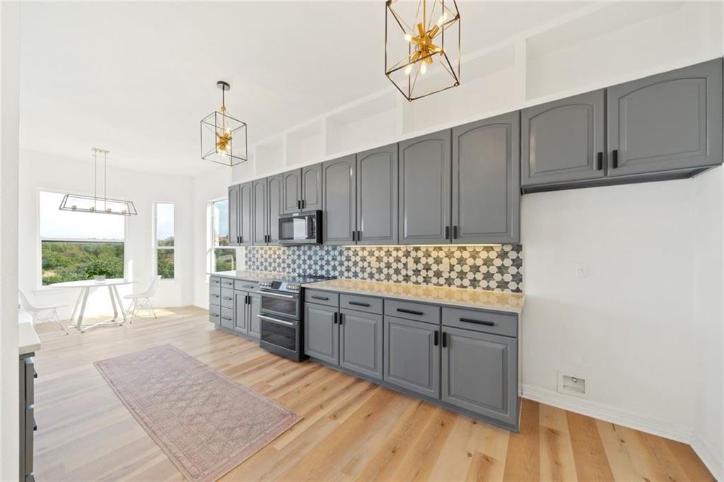13301 Lone Rider Trail Bee Cave, TX 78738 - Photo 16 of 21 This kitchen features light wood flooring and extensive grey cabinetry with black hardware