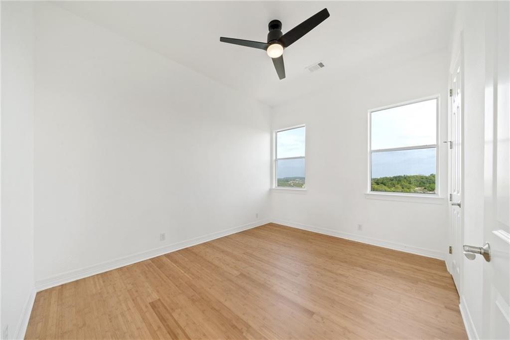 13301 Lone Rider Trail Bee Cave, TX 78738 - Photo 17 of 21 This room features light hardwood flooring, white walls, and a modern ceiling fan