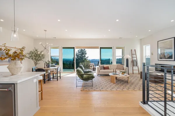 a dining room with furniture a chandelier and kitchen view