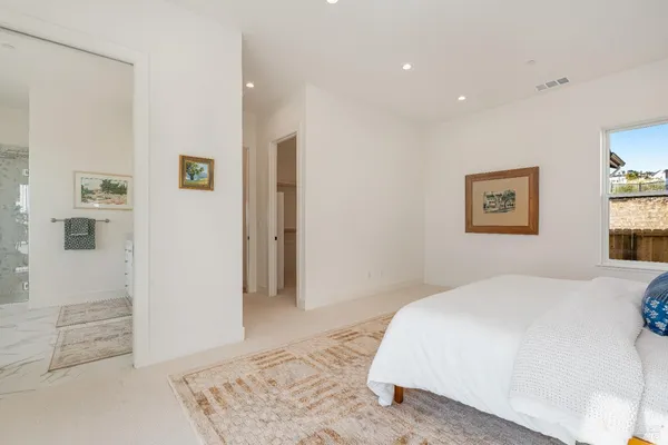 a spacious bedroom with a bed and a shower