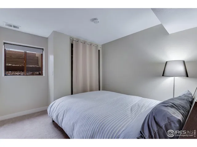 a bedroom with a bed and painting on the wall