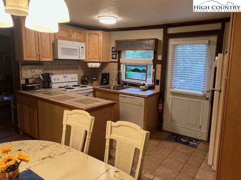 392 Old Danner Road Vilas, NC 28692 - Photo 13 of 34 a kitchen with a sink a stove cabinets and a window