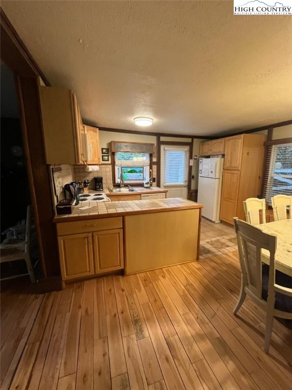 392 Old Danner Road Vilas, NC 28692 - Photo 15 of 34 a kitchen with wooden floors and wooden cabinets