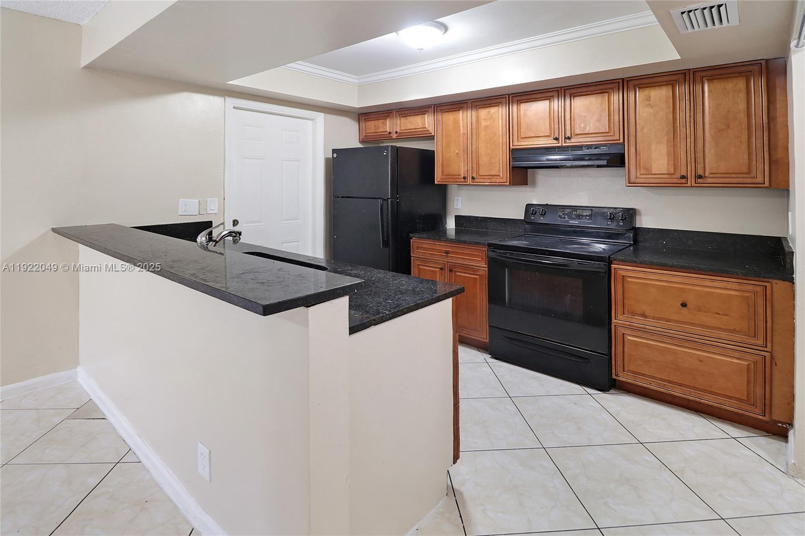 6533 Harbour Road North Lauderdale, FL 33068 - Photo 3 of 20 a kitchen with granite countertop a refrigerator and a stove