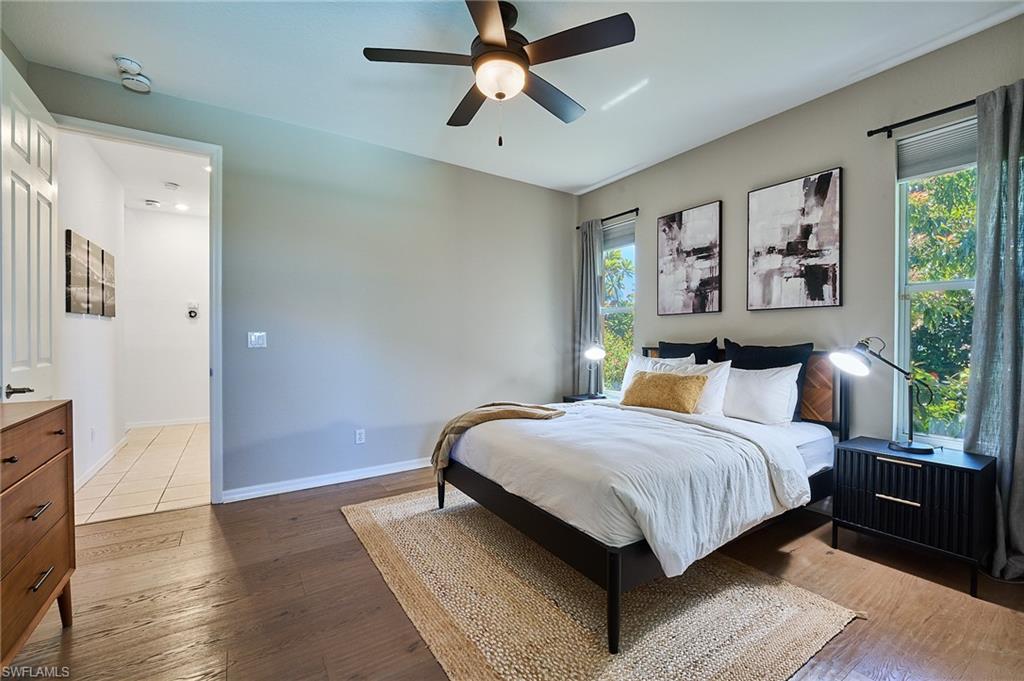 186 Muirfield Circle Naples, FL 34113 - Photo 20 of 36 a bedroom with a large bed and a chandelier