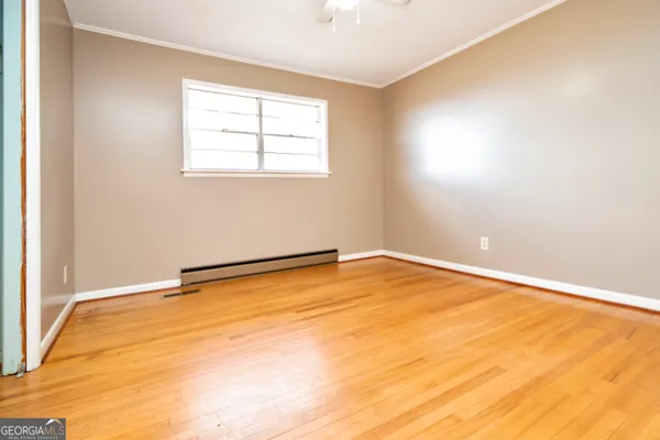 a view of empty room with wooden floor