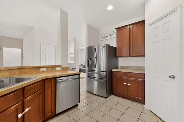 a kitchen with stainless steel appliances granite countertop a refrigerator and a sink