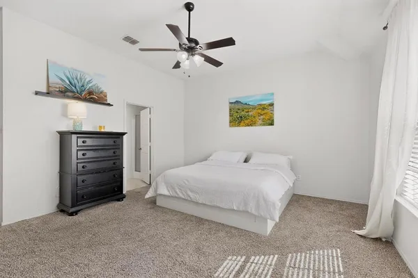 a bedroom with a bed and a ceiling fan