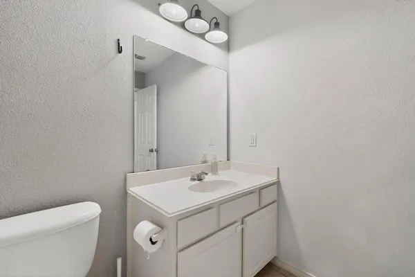a bathroom with a sink a toilet and a mirror
