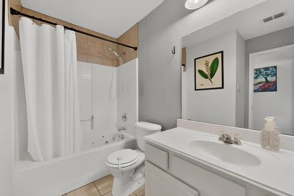 a bathroom with a sink a toilet and shower curtain
