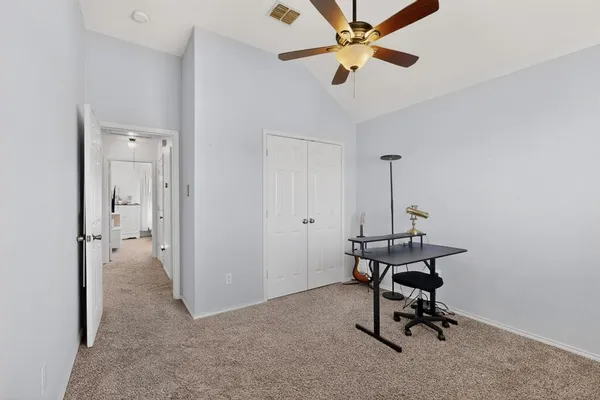 a view of a workspace with furniture and a ceiling fan