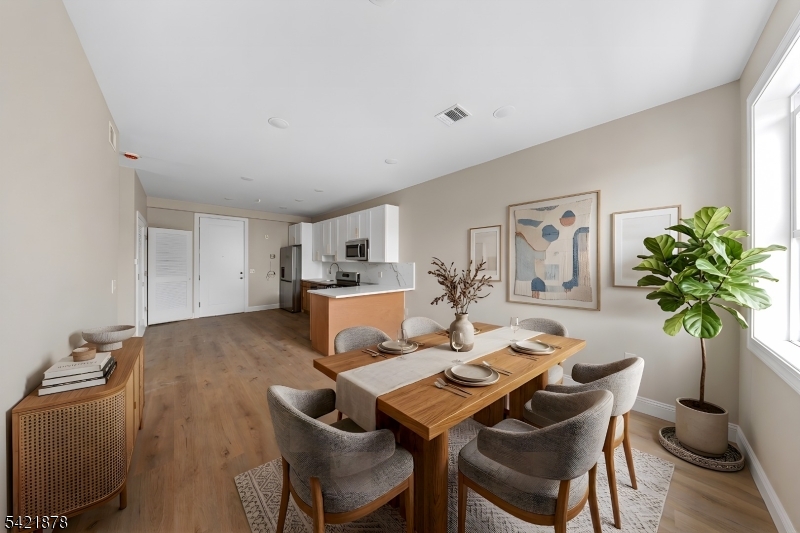 17 Wickham Street, Unit 203 Passaic, NJ 07055 - Photo 15 of 15 a view of a dining room with furniture and a potted plant