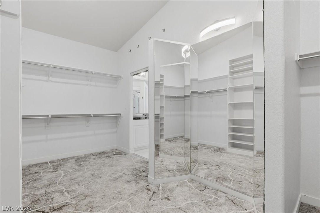 2413 Gold Camp Street Henderson, NV 89002 - Photo 45 of 66 Carpeted Primary closet that dreams are made of. Complete with built in dressing mirror and custom closet shelving and vaulted ceilings.