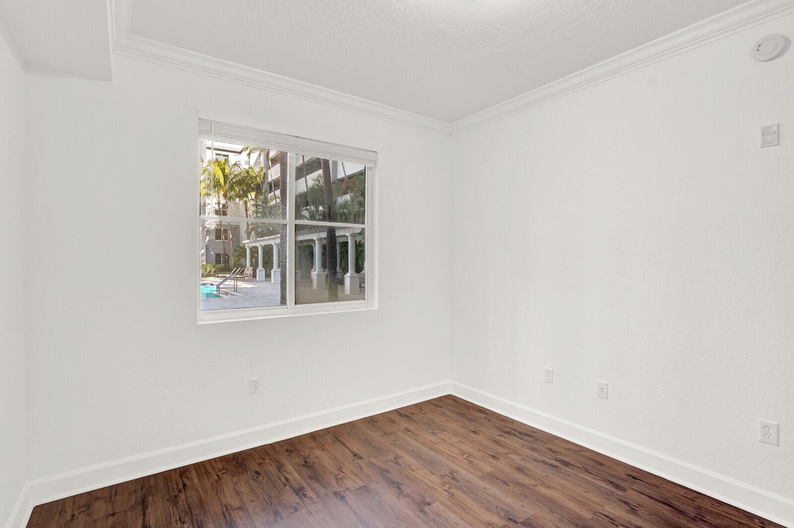 1690 Renaissance Commons Boulevard, Unit 1121 Boynton Beach, FL 33426 - Photo 11 of 32 a view of an empty room with wooden floor and a window