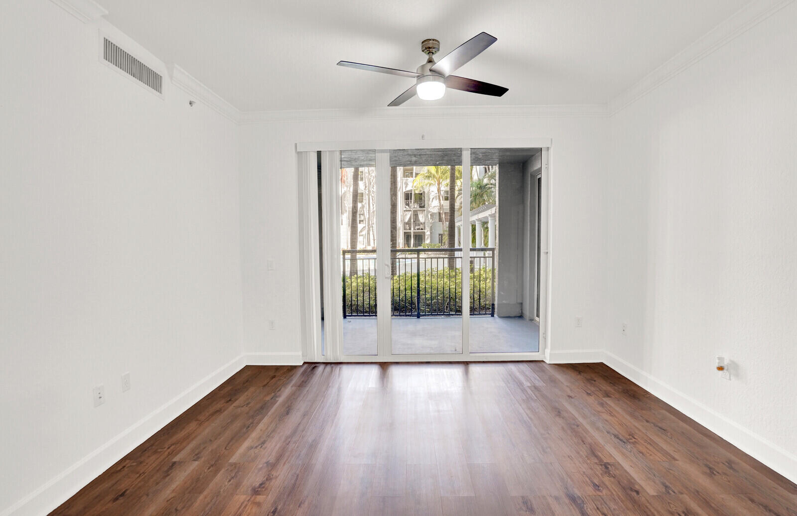 1690 Renaissance Commons Boulevard, Unit 1121 Boynton Beach, FL 33426 - Photo 6 of 35 an empty room with wooden floor and windows