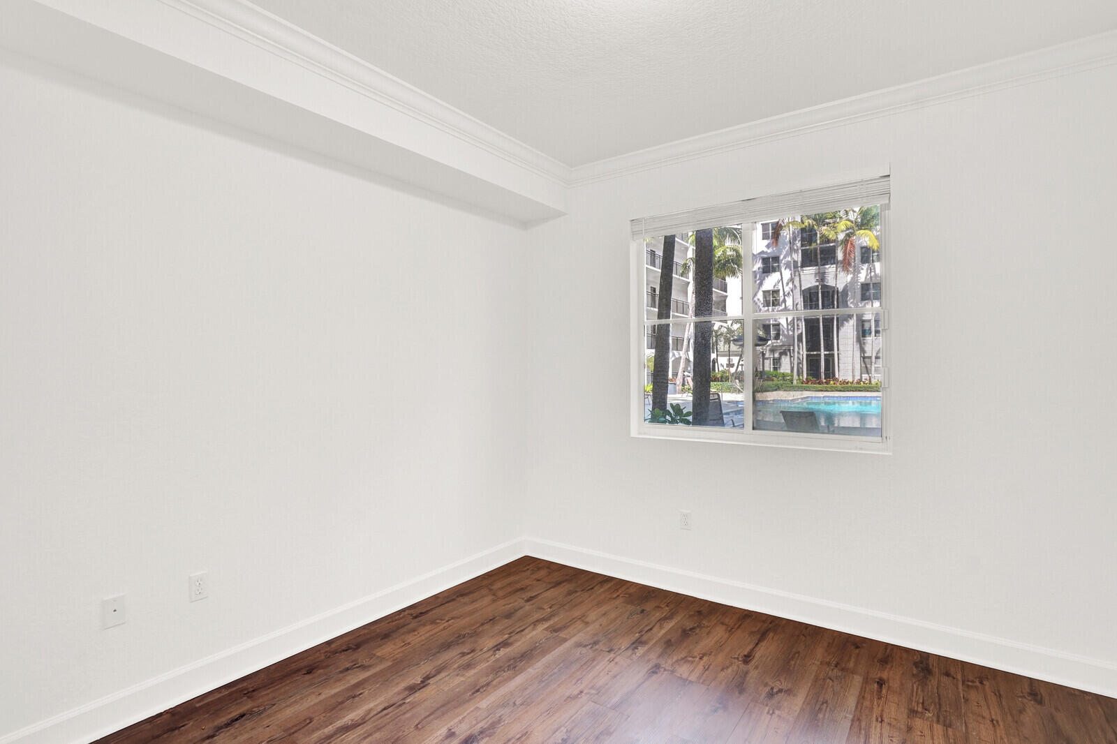 1690 Renaissance Commons Boulevard, Unit 1121 Boynton Beach, FL 33426 - Photo 10 of 32 an empty room with wooden floor and windows