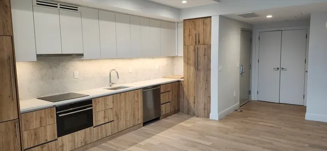 a kitchen with stainless steel appliances granite countertop a sink and a stove top oven