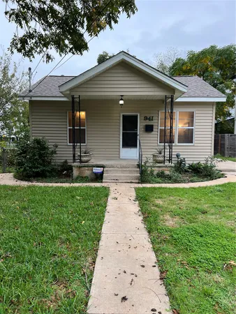 a front view of a house with a garden and yard