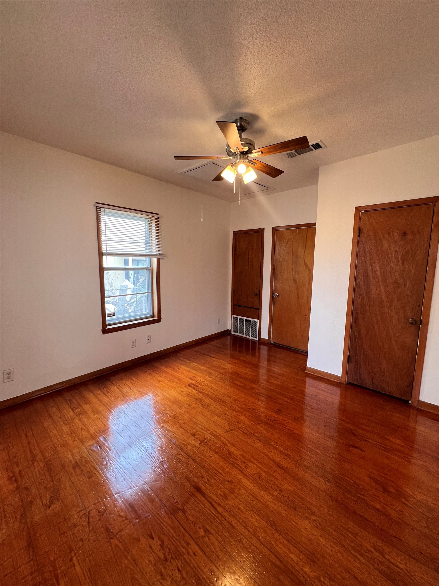 941 East 52nd Street Austin, TX 78751 - Photo 11 of 26 a view of an empty room with wooden floor and a ceiling fan