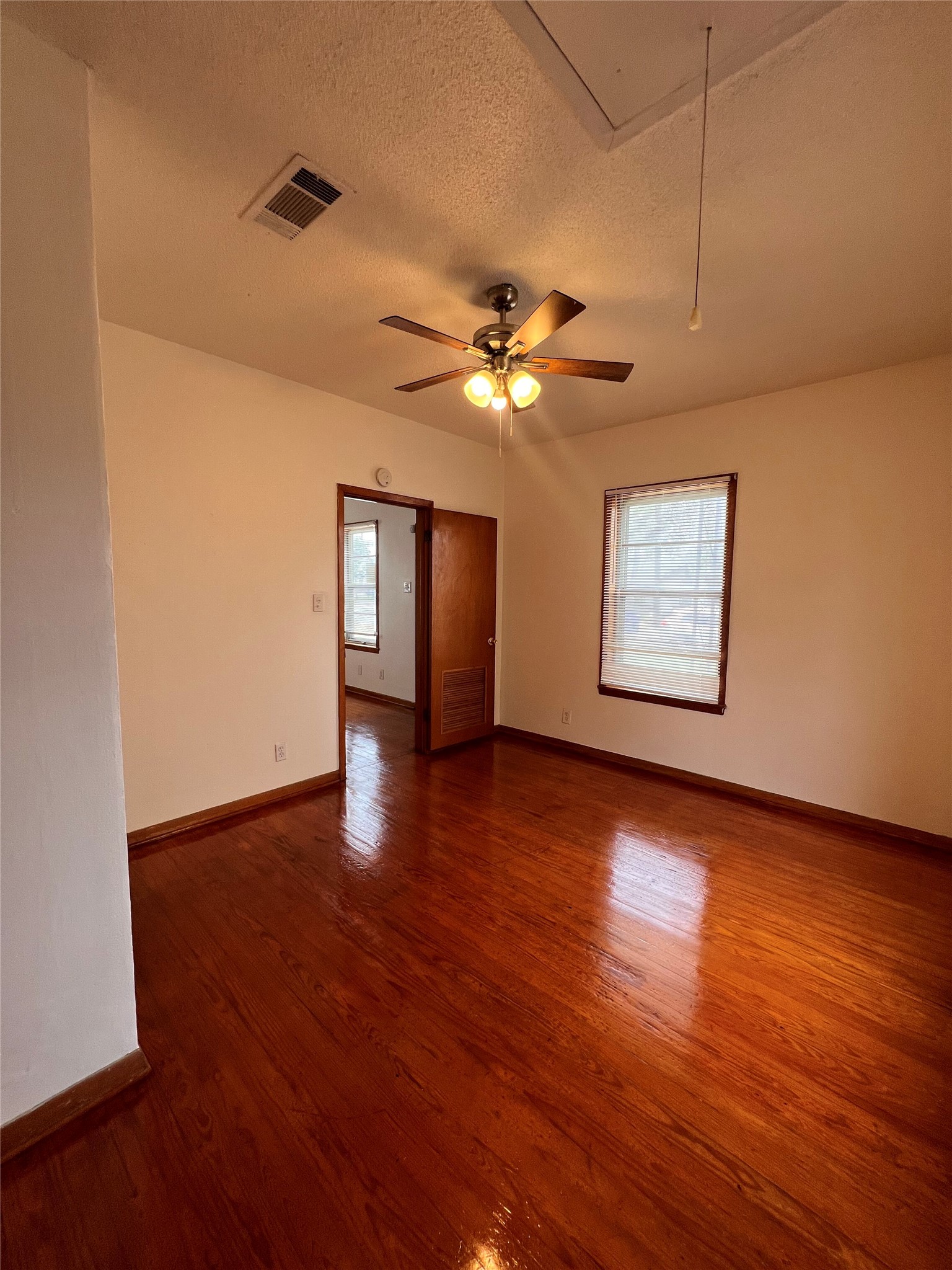 941 East 52nd Street Austin, TX 78751 - Photo 12 of 26 a view of an empty room with a window and wooden floor