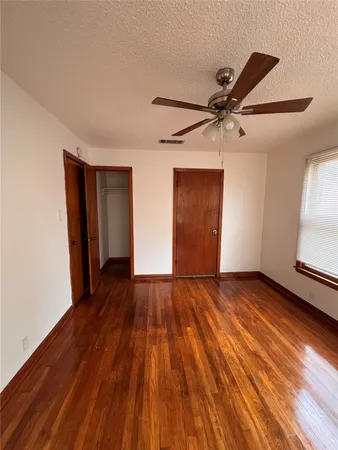 a view of an empty room and window with wooden floor