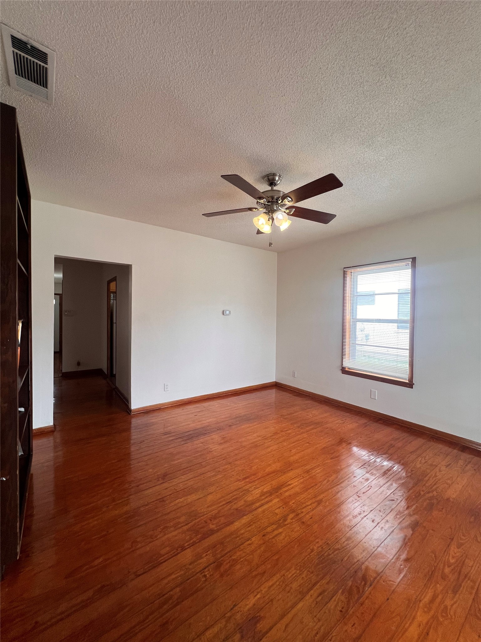 941 East 52nd Street Austin, TX 78751 - Photo 10 of 26 a view of an empty room with wooden floor and a ceiling fan