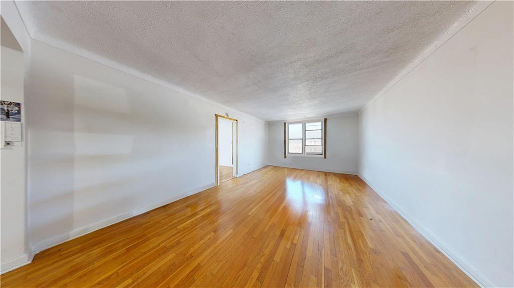 7401 Shore Road, Unit 6F Brooklyn, NY 11209 - Photo 5 of 14 a view of empty room with window and wooden floor