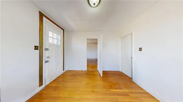 a view of a room with wooden floor and white walls